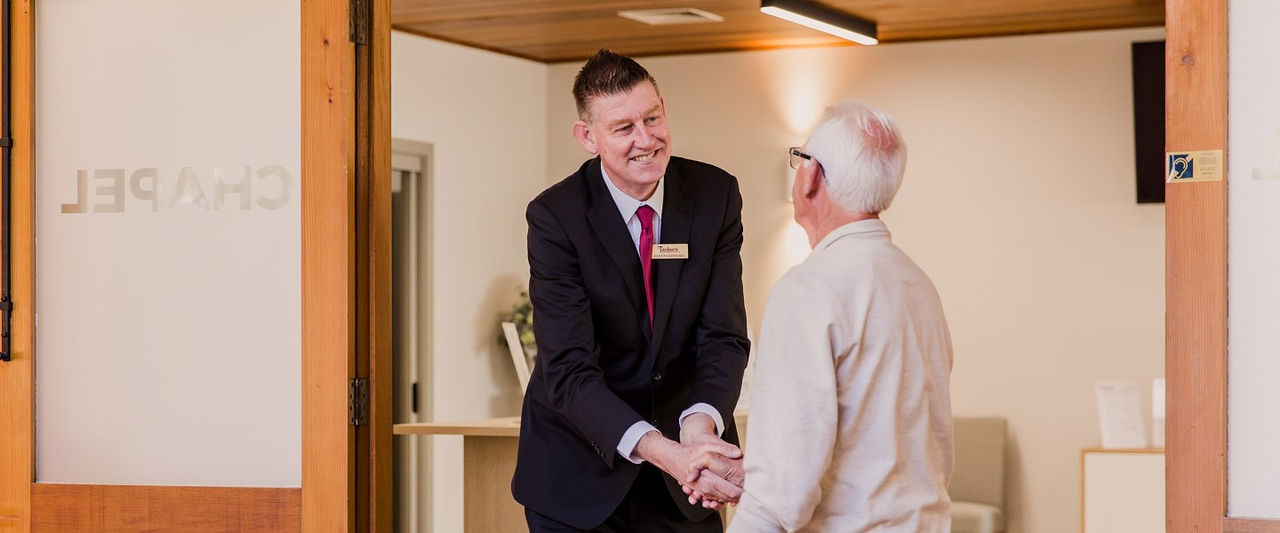 Tuckers funeral director greeting a man at the chapel