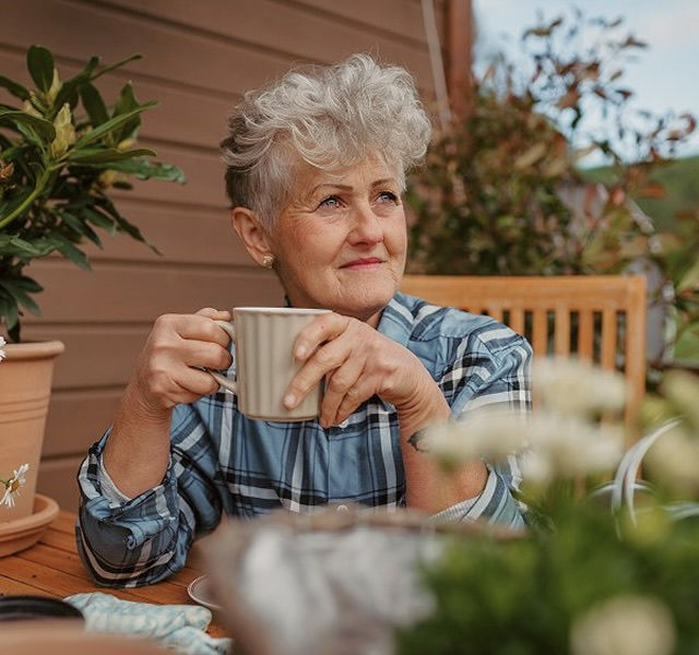 an elderly woman drinking tea