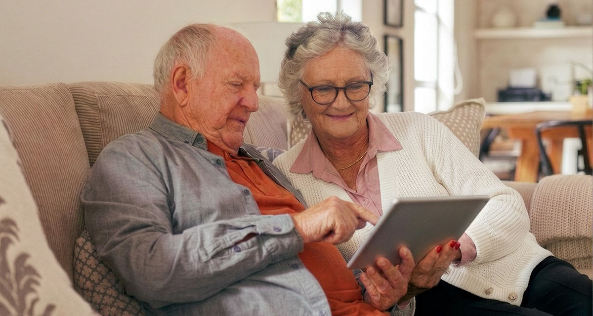 a man and a woman looking at an iPad