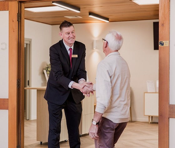Tuckers funeral director greeting a man at the chapel