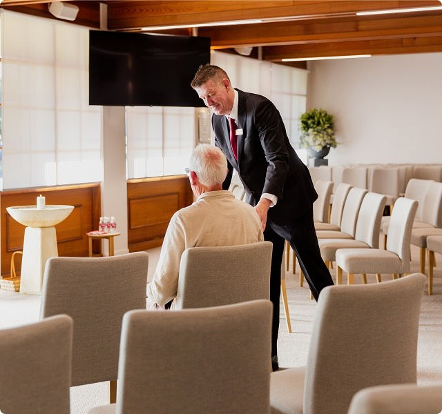 Tuckers funeral director with man in chapel